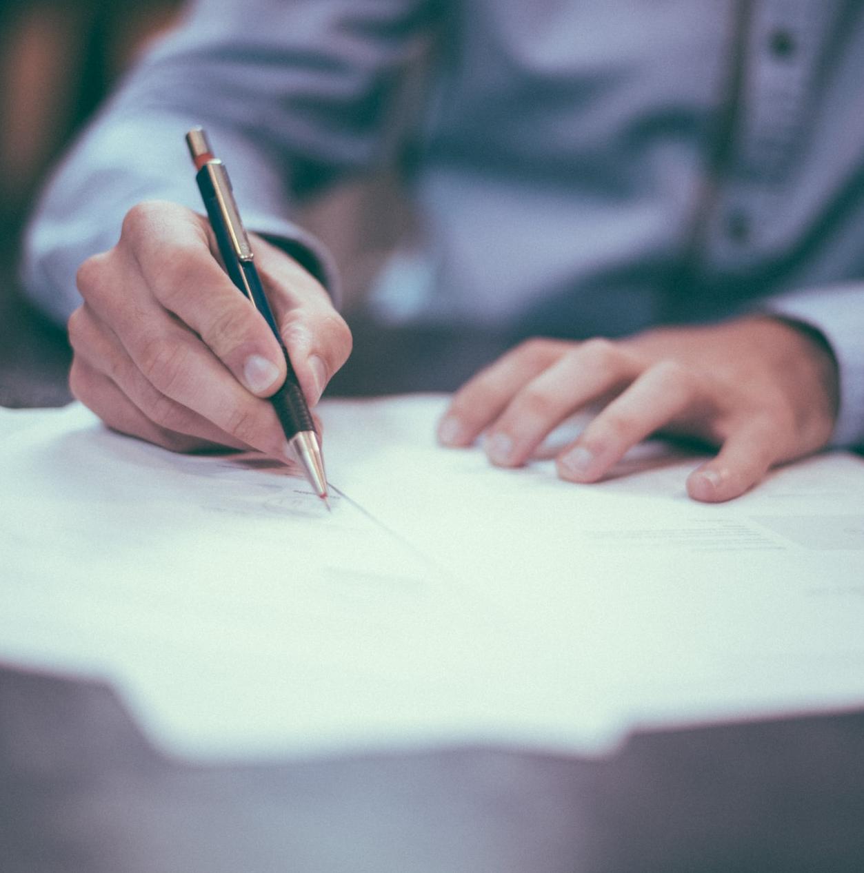 man writing on paper